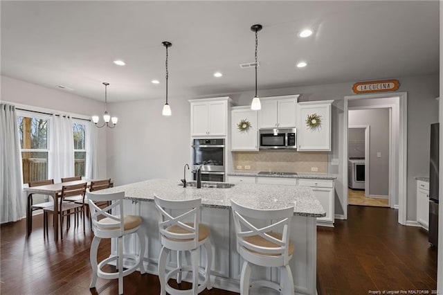 kitchen featuring white cabinets, an island with sink, and appliances with stainless steel finishes