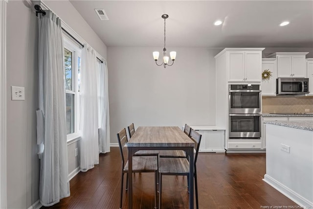 dining space featuring an inviting chandelier and dark wood-type flooring