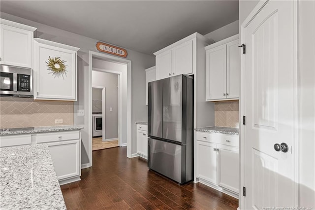 kitchen with white cabinetry, light stone countertops, dark hardwood / wood-style floors, backsplash, and appliances with stainless steel finishes