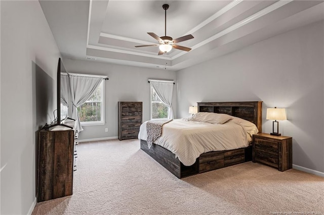 carpeted bedroom featuring a tray ceiling and ceiling fan