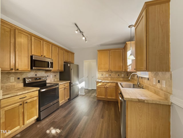 kitchen with decorative backsplash, dark hardwood / wood-style flooring, stainless steel appliances, sink, and pendant lighting