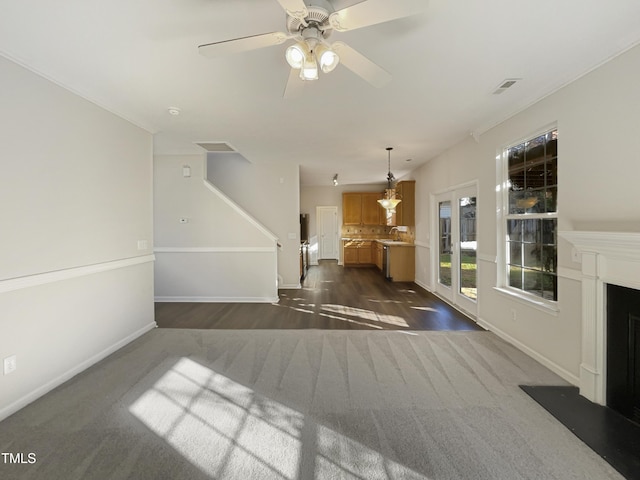 unfurnished living room featuring ceiling fan, dark hardwood / wood-style flooring, french doors, and sink