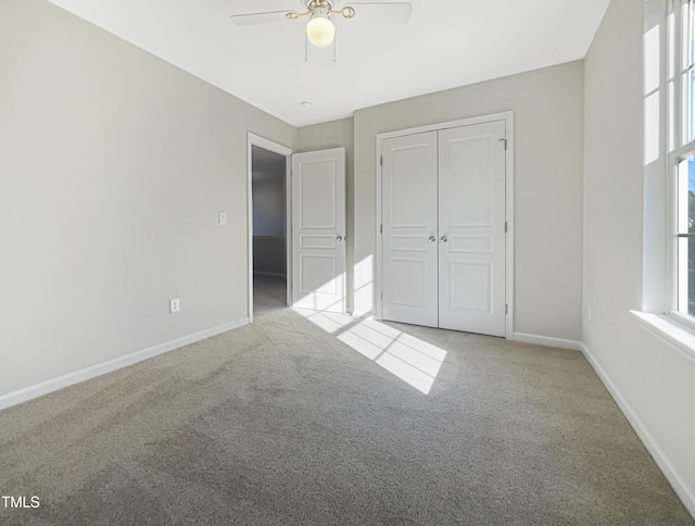 unfurnished bedroom featuring light carpet, a closet, multiple windows, and ceiling fan