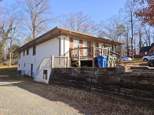 view of property exterior featuring a wooden deck and cooling unit