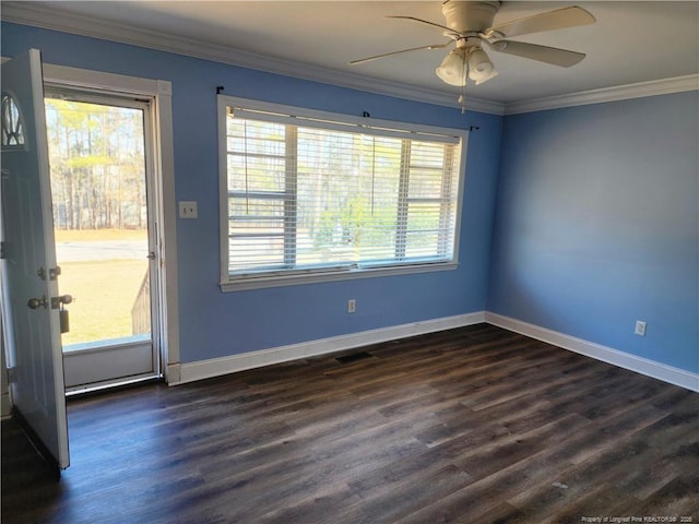 spare room featuring a wealth of natural light, ornamental molding, dark hardwood / wood-style floors, and ceiling fan