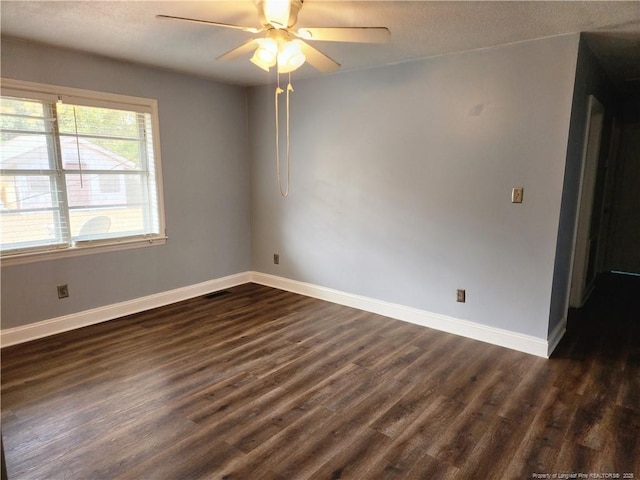 spare room with dark wood-type flooring and ceiling fan