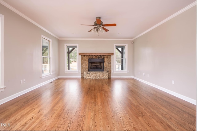 unfurnished living room featuring a fireplace, wood-type flooring, ceiling fan, and ornamental molding