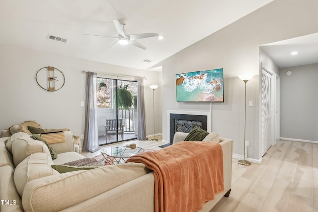 living room with ceiling fan, lofted ceiling, and light hardwood / wood-style flooring