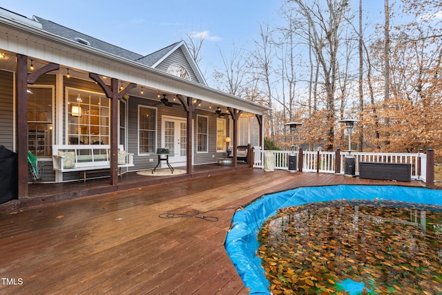 view of swimming pool featuring ceiling fan and a deck