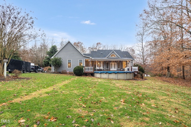 back of house featuring a yard and a covered pool