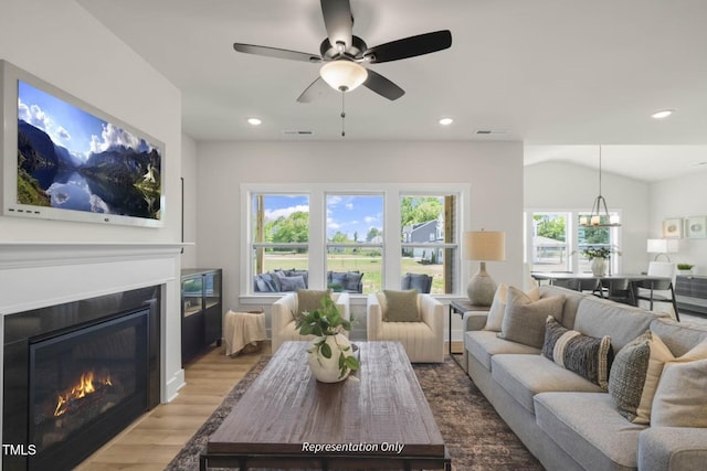 living room featuring ceiling fan, lofted ceiling, a wealth of natural light, and light hardwood / wood-style flooring