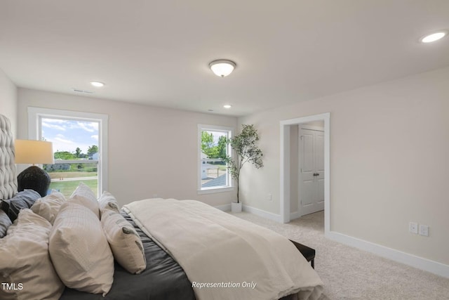 bedroom featuring light carpet and multiple windows