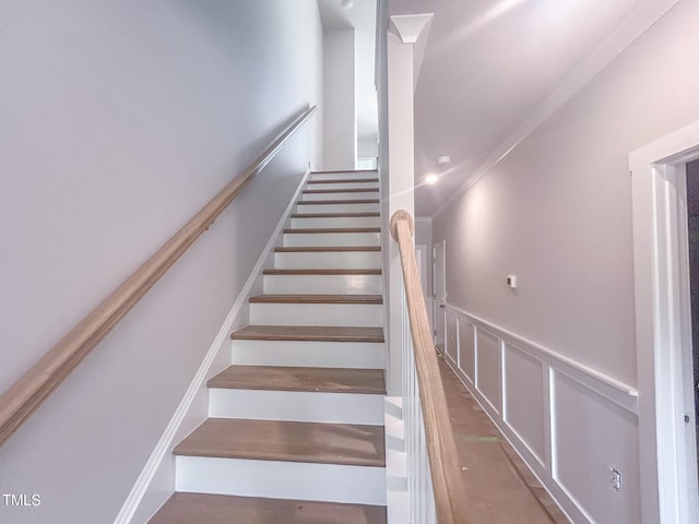 stairs featuring a wainscoted wall and a decorative wall