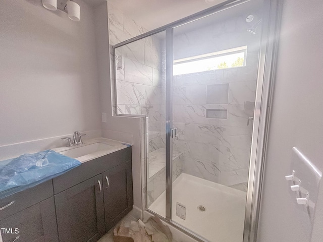 full bath with a marble finish shower and vanity
