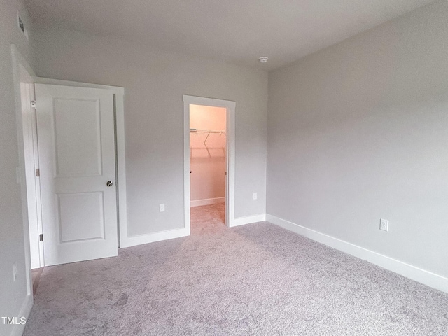 207 Pond View Ct Unit 3, Fuquay Varina, NC 27526 - unfurnished bedroom featuring a walk in closet, carpet floors, baseboards, and a closet