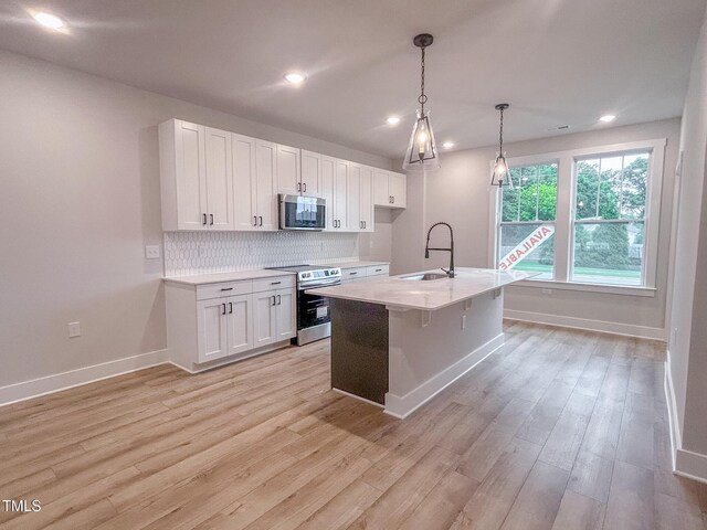 207 Pond View Ct Unit 3, Fuquay Varina, NC 27526 - kitchen with stainless steel appliances, a sink, white cabinets, light wood-style flooring, and baseboards