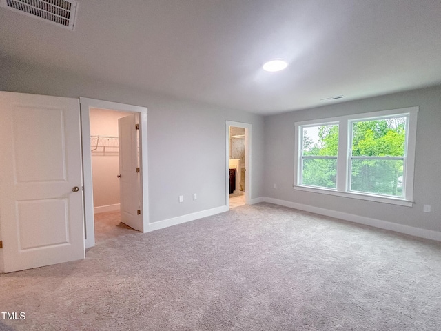 207 Pond View Ct Unit 3, Fuquay Varina, NC 27526 - unfurnished bedroom with a walk in closet, baseboards, carpet, connected bathroom, and a closet
