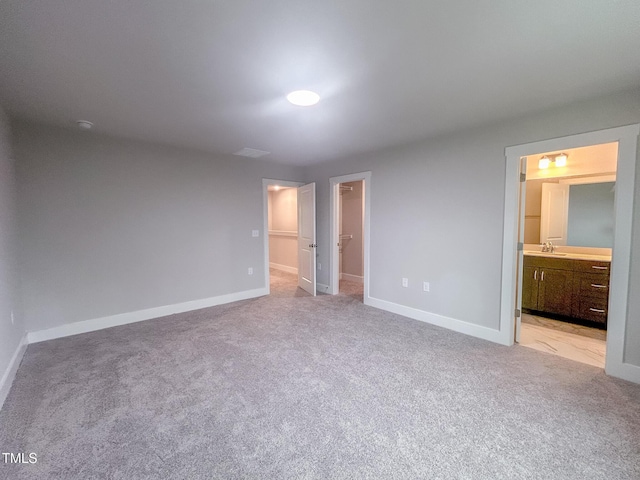 207 Pond View Ct Unit 3, Fuquay Varina, NC 27526 - unfurnished bedroom featuring light carpet, a walk in closet, a sink, and baseboards