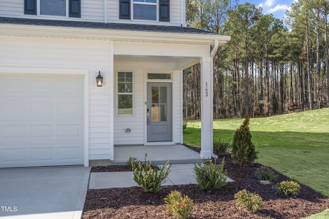 view of exterior entry featuring a lawn and a garage