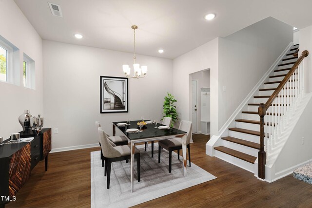 dining space featuring dark hardwood / wood-style floors and an inviting chandelier