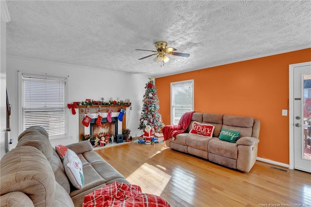 living room featuring ceiling fan, a textured ceiling, and hardwood / wood-style flooring