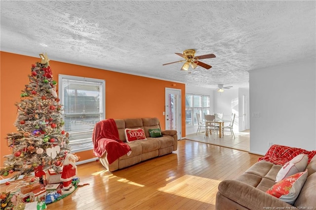 living room with a wealth of natural light, ceiling fan, a textured ceiling, and hardwood / wood-style flooring