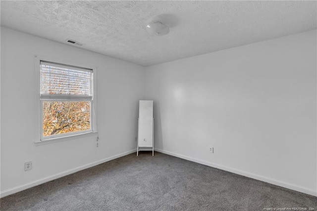 carpeted empty room with a textured ceiling