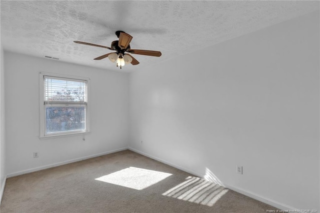 carpeted empty room featuring ceiling fan and a textured ceiling