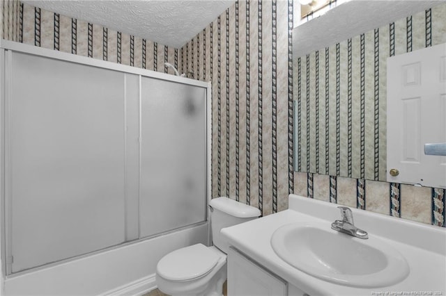 full bathroom with vanity, a textured ceiling, toilet, and bath / shower combo with glass door