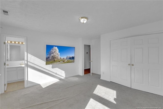 unfurnished living room with a textured ceiling and light colored carpet