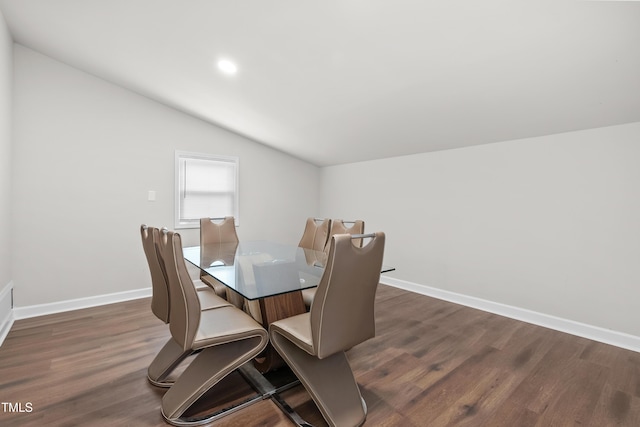 dining area featuring lofted ceiling and dark wood-type flooring