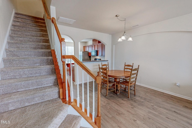 dining room with hardwood / wood-style floors and a notable chandelier