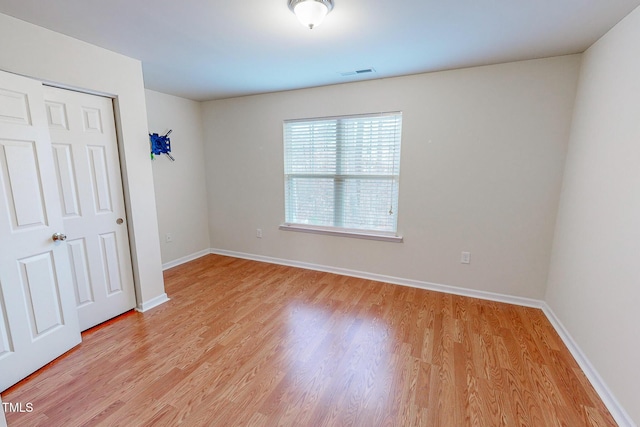 unfurnished bedroom with light wood-type flooring and a closet