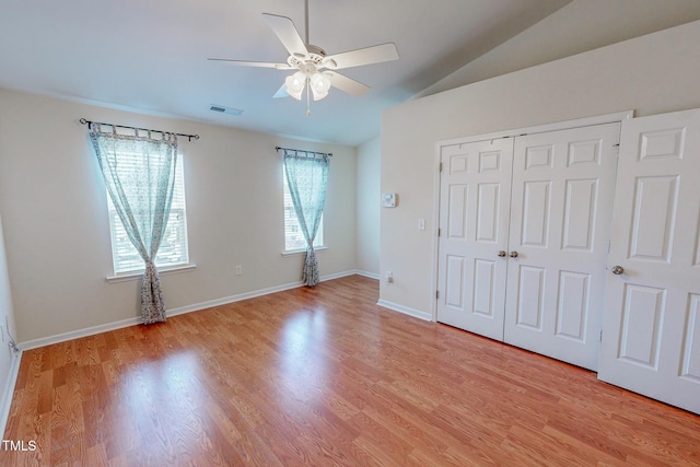 unfurnished bedroom featuring a closet, ceiling fan, light hardwood / wood-style flooring, and lofted ceiling