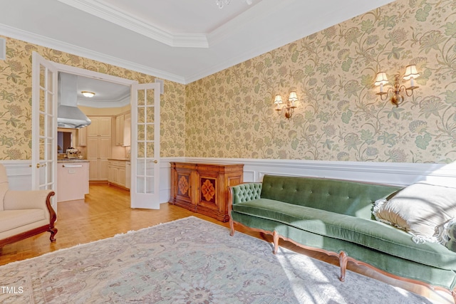 sitting room with crown molding, french doors, and light hardwood / wood-style floors