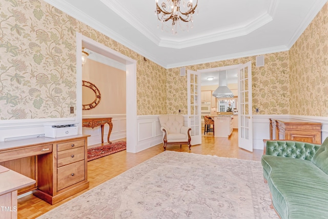 sitting room with light parquet flooring, a tray ceiling, ornamental molding, and a notable chandelier