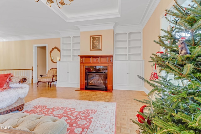 living room featuring built in shelves, crown molding, and light parquet floors