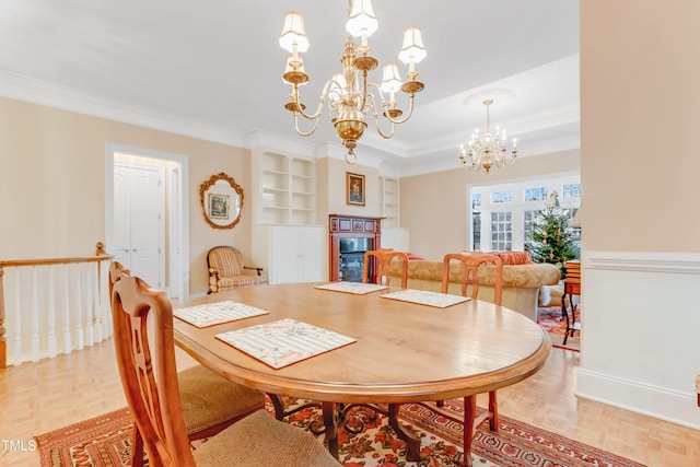 dining room featuring a chandelier, light parquet floors, built in features, and ornamental molding