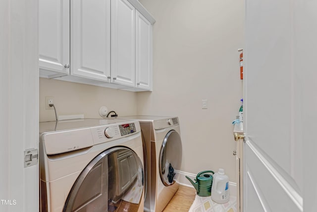 laundry room with cabinets, separate washer and dryer, and light hardwood / wood-style floors