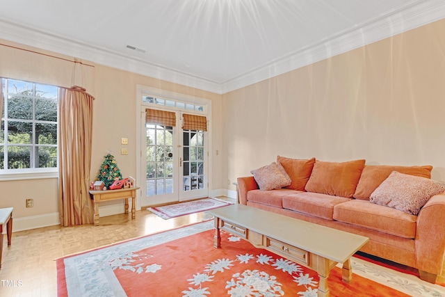 living room with a healthy amount of sunlight, parquet flooring, crown molding, and french doors