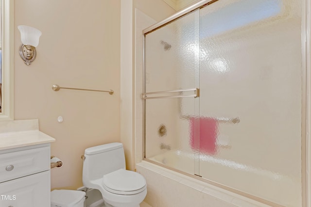 full bathroom with vanity, enclosed tub / shower combo, and toilet