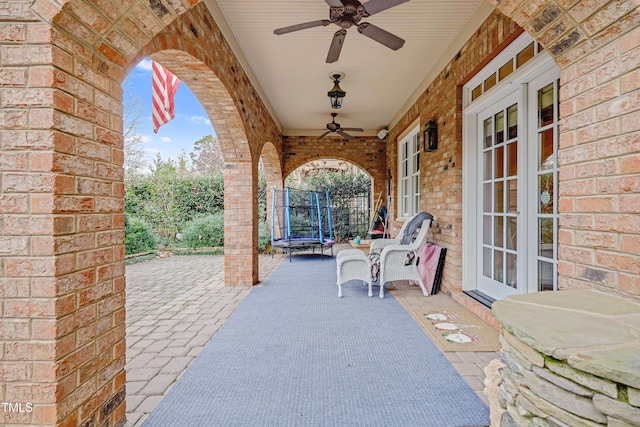 view of patio with ceiling fan and a trampoline