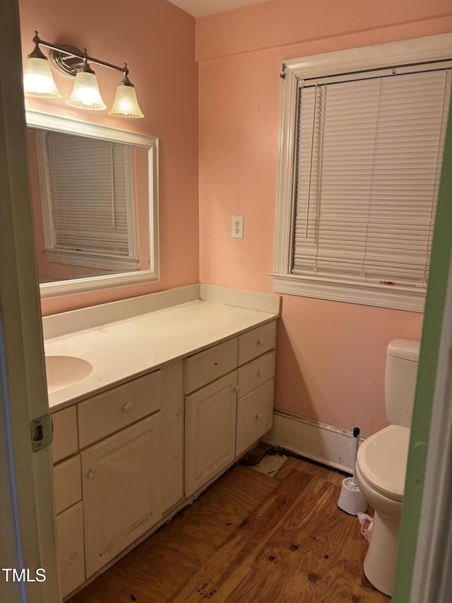 bathroom with hardwood / wood-style flooring, vanity, and toilet