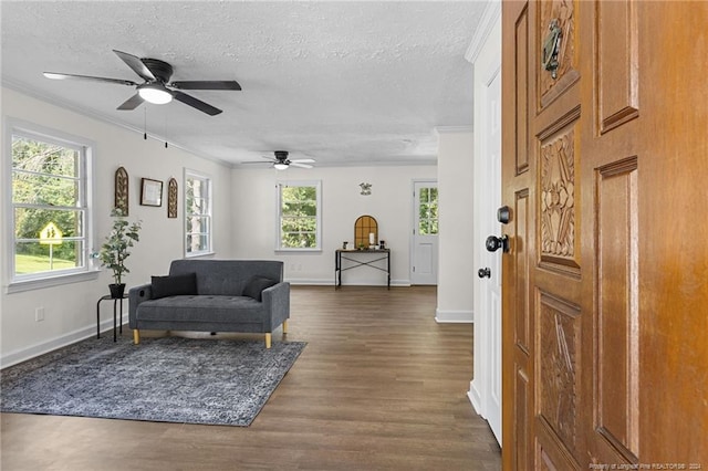 living room featuring a textured ceiling, dark hardwood / wood-style flooring, ceiling fan, and crown molding