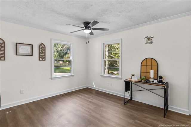 spare room featuring a textured ceiling, plenty of natural light, dark wood-type flooring, and ceiling fan