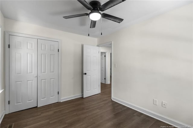 unfurnished bedroom with a closet, dark hardwood / wood-style floors, and ceiling fan