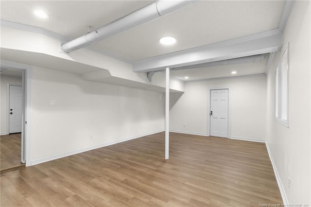 basement with hardwood / wood-style floors and ornamental molding