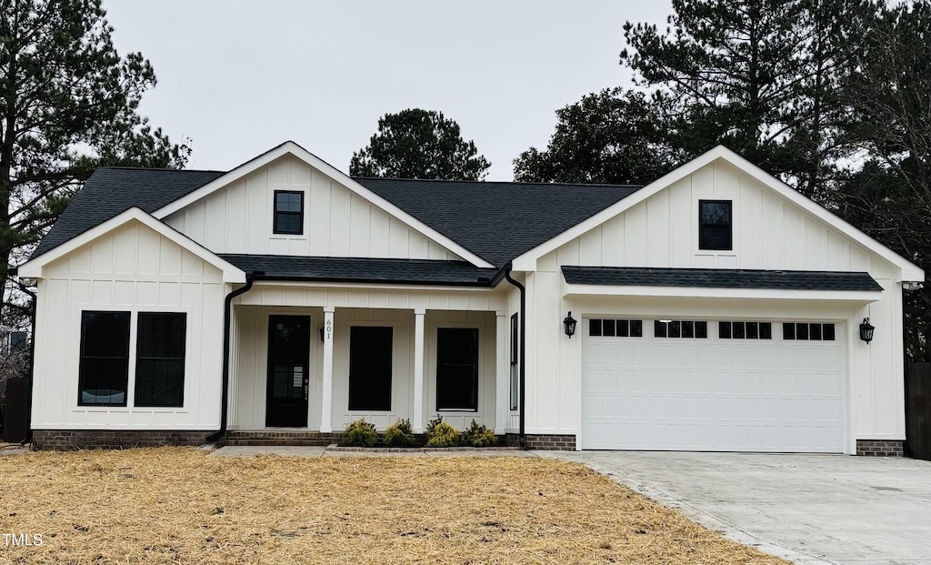 modern farmhouse style home featuring covered porch and a garage