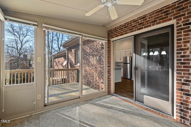 unfurnished sunroom featuring ceiling fan