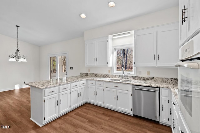 kitchen featuring white cabinets, dishwasher, dark wood-style flooring, a peninsula, and a sink